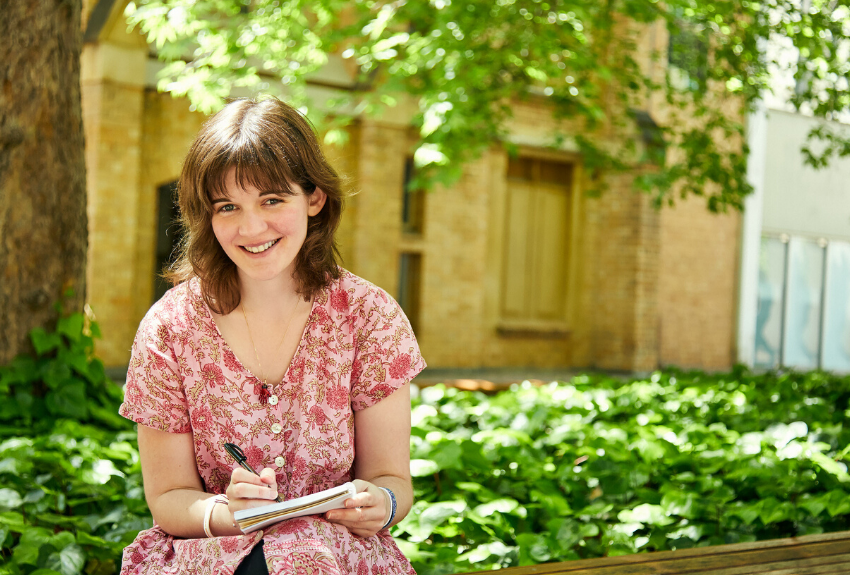 Sophie-sitting-outdoors-holding-pen-and-notebook