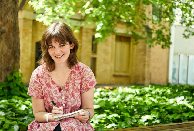 Sophie-sitting-outdoors-holding-pen-and-notebook