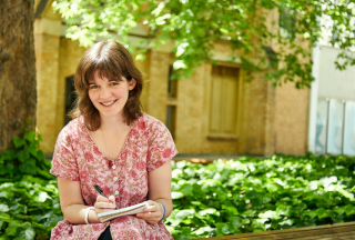 Sophie-sitting-outdoors-holding-pen-and-notebook
