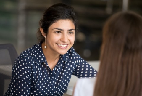 Person leans forward to listen to someone they are talking to