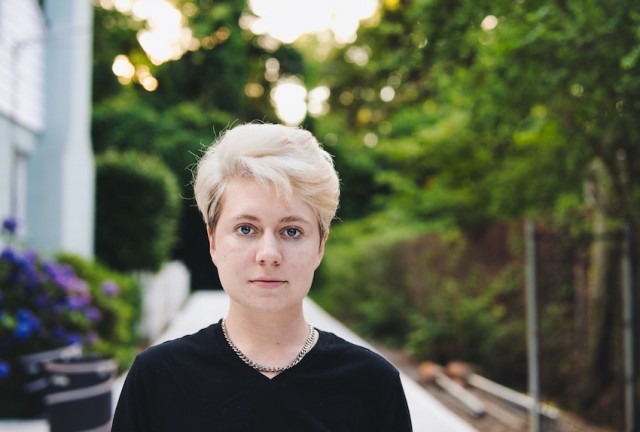 Non-binary adult standing outside looking calm and serious